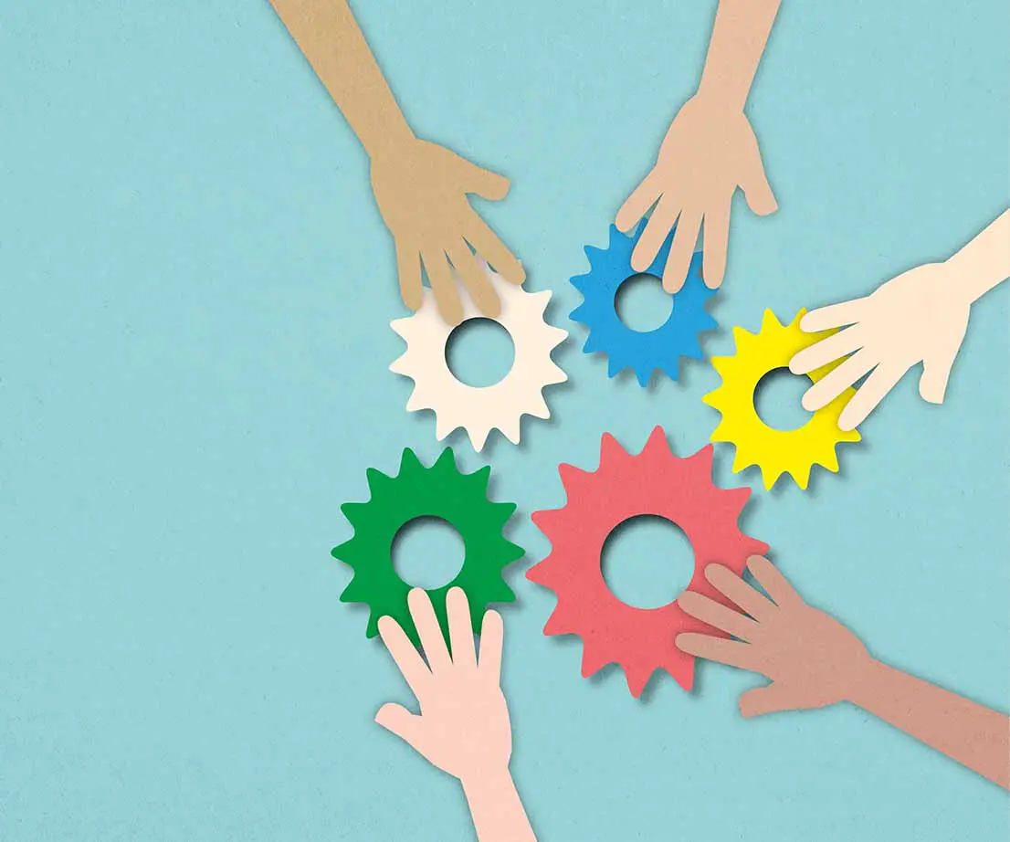 mehrere Hände berühren bunte Zahnräder