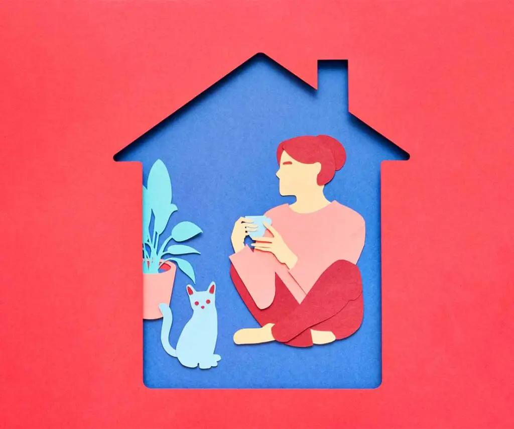 im Haus sitzende Frau mit Tasse in den Händen