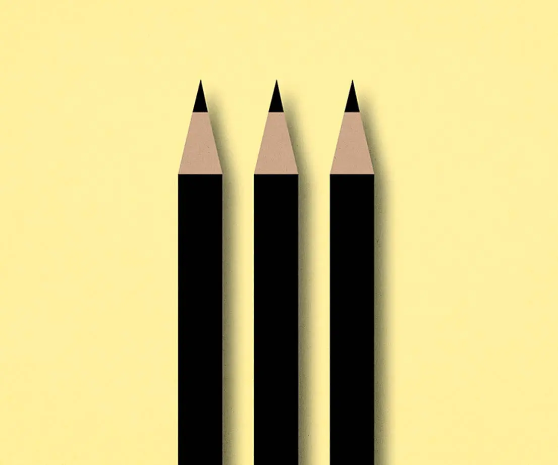 schwarze Bleistifte vor gelbem Hintergrund